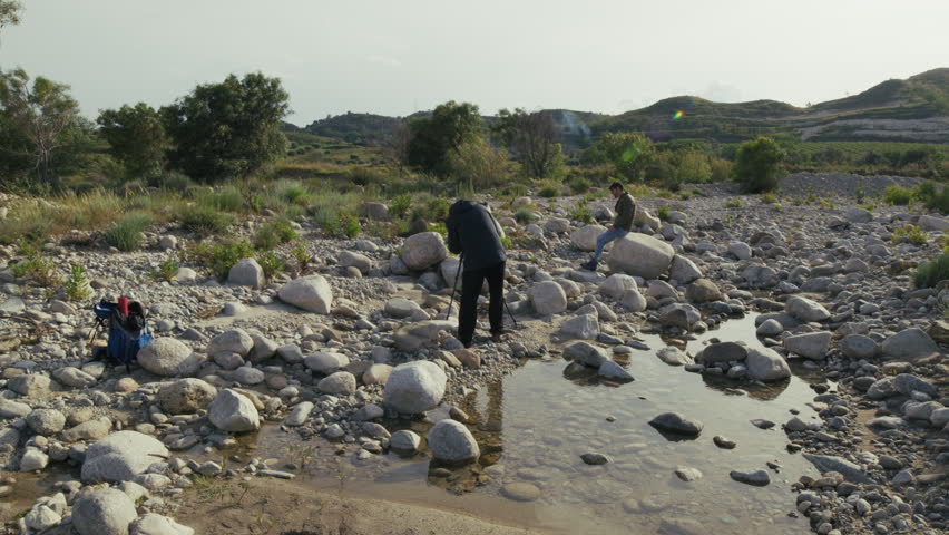Two Explorers Take a Picture of Themselves in a River Bed in Spring