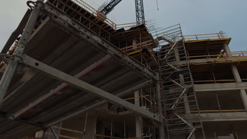 Scaffolding structure shows progress and safety. Temporary walkway with guard rails aids construction team