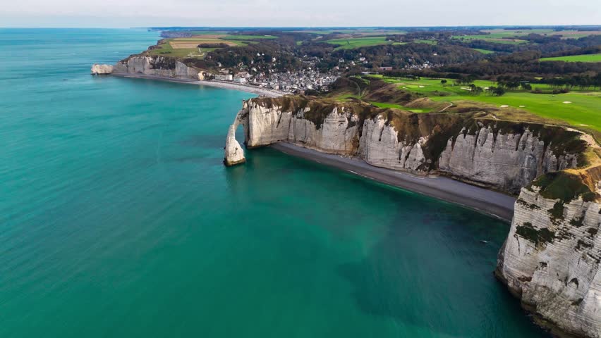 Aerial drone view of picturesque coastal limestone cliffs and the English Channel town of Etretat, France. High quality 4k footage