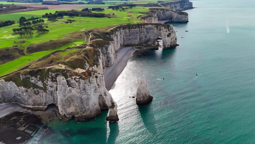 Aerial drone view of picturesque coastal limestone cliffs and the English Channel town of Etretat, France. High quality 4k footage
