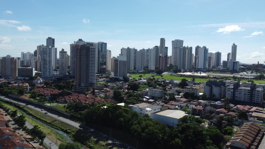 Aerial drone tracking back shot revealing a wide panorama of the Jardim Goias district skyline and urban residential areas in Goiania, Brazil.