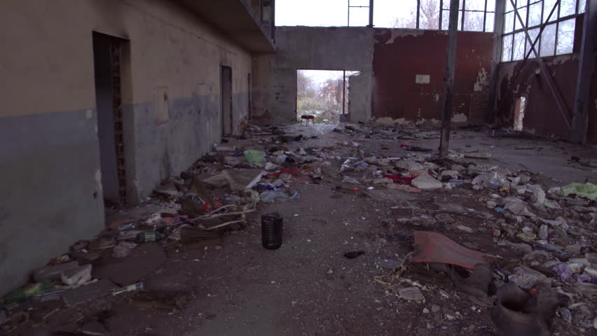 An old, abandoned, scary, creepy, horror house inside an industrial zone in decay with broken furniture ruins, garbage and trash from the communist era on the Balkans in Bulgaria, Eastern Europe.