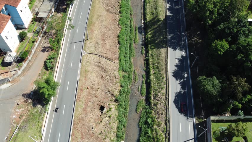 Static drone tilt-up shot starting from the Marginal Botafogo expressway to reveal a wide urban panorama and modern high-rise skyline in Goiania, Brazil.