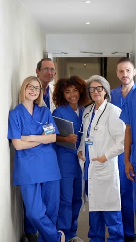 Professional group of multicultural medical workers, including doctors and nurses, smiling and posing together in a modern clinic, showcasing teamwork and healthcare expertise