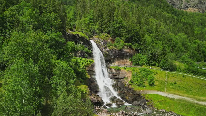 Drone aerial view of Steinsdalsfossen waterfall surrounded by lush forest in western Norway.