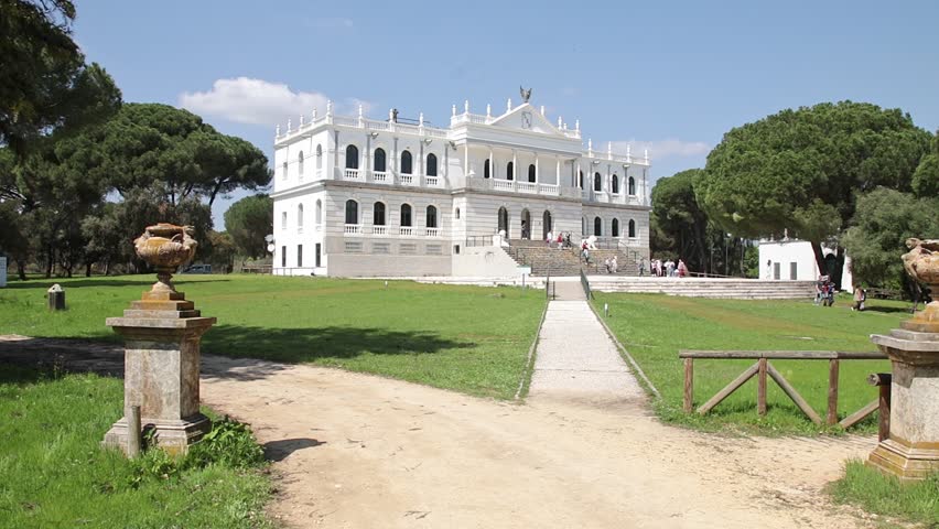 Neoclassical white palace facade in Doñana National Park. Scenic view of the historical Acebron Palace building surrounded by pine trees and green gardens in Almonte, Spain.