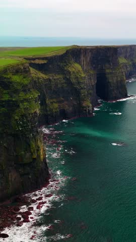 Vertical aerial drone view of the Cliffs of Moher in Ireland. Dramatic coastal cliffs and the vast Atlantic Ocean. One of the most beautiful natural landmarks in Ireland.	
