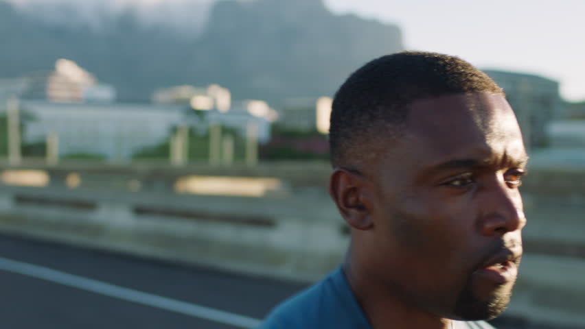 Black man, running and speed on bridge for fitness in city for cardio, training and wellness in summer. African person, outdoor and fast sprint with challenge, workout and exercise in urban street