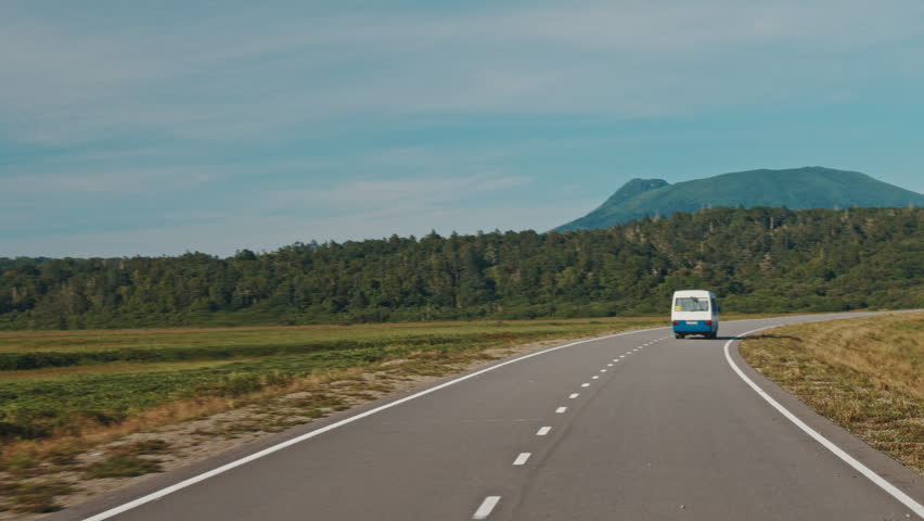 Car speeds up and overtakes. Car moves fast on the asphalt road in the valley