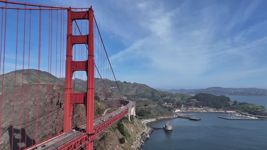 Aerial drone view of Golden Gate Bridge traffic and Fort Baker bay in San Francisco, California.