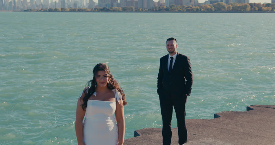 Romantic groom approaching and kissing his bride by the lake