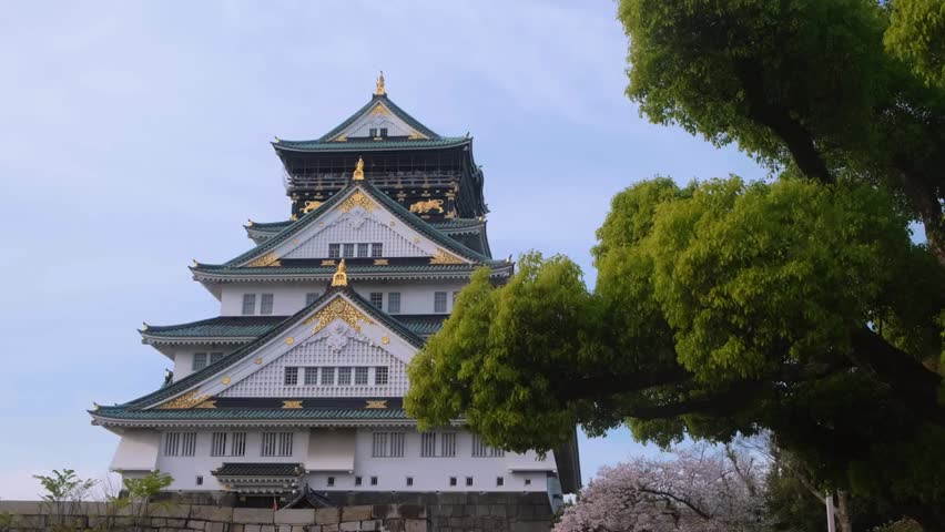 Scenic view of Osaka Castle in Japan under a clear blue sky, showcasing historical architecture, cultural heritage, and iconic city landmarks.