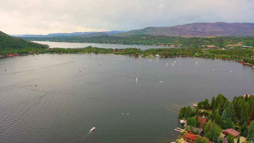 Aerial view of Lake George New York with boats on the water, shoreline homes, and broad Adirondack scenery surrounding a scenic summer lake destination