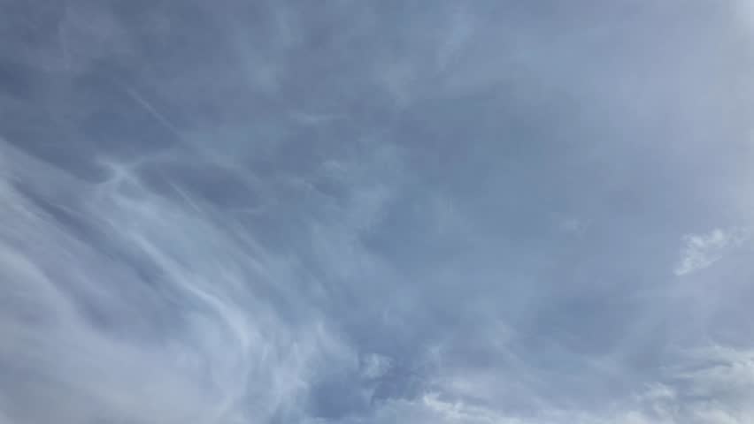 White clouds float across the blue sky. Puffy fluffy soft clouds. Timelapse