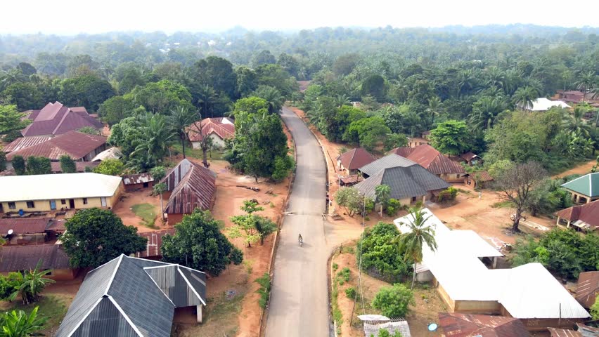 High-resolution aerial drone footage capturing a traditional rural village landscape in Cross River State, Nigeria. Scenic view of local settlements surrounded by natural vegetation, showcasing everyday life and environment in a peaceful countryside setting. Ideal for documentary, travel, culture, and African lifestyle visuals.
