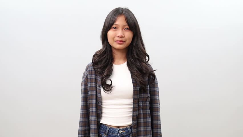 Smiling young Asian teenager girl looking in camera feeling happy and cheerful