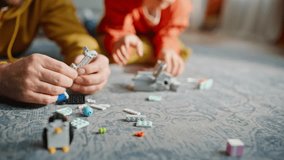 Father son hands constructing game blocks on floor modern living room closeup. Creative child loving parent playing colorful constructor. Happy bearded man dad talking spending weekend adorable boy. - Powered by Shutterstock - Get 15% off with code: PIKWIZARD15