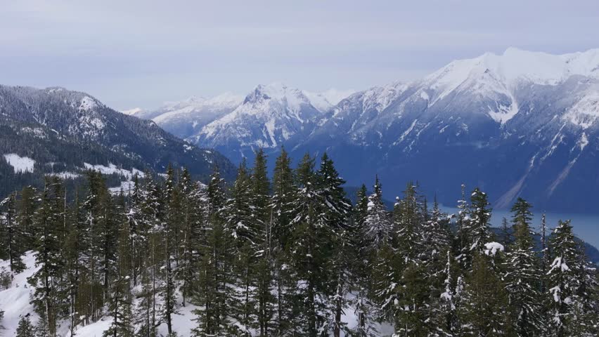 Majestic Winter Landscape Over British Columbia, Canada, With Snow-Capped Mountains and Evergreen Forests