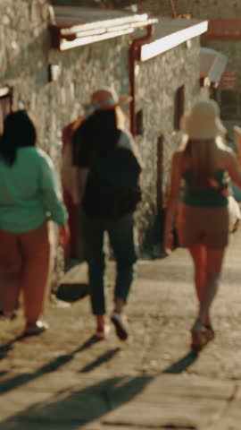 Women, friends and back in harbor with travel on holiday, chat and point with sightseeing trip. Happy people, group and outdoor in town for discussion, tourism or direction with buildings on vacation