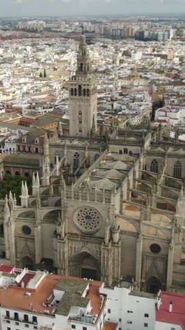 Vertical aerial view highlighting Seville Cathedral and its magnificent La Giralda bell tower.