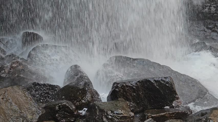 The spray from the waterfall is washing over the rocks