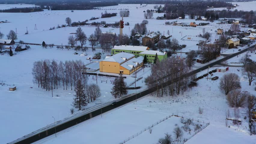 Snow-covered village, showing roads, buildings, and trees in cold season, aerial view