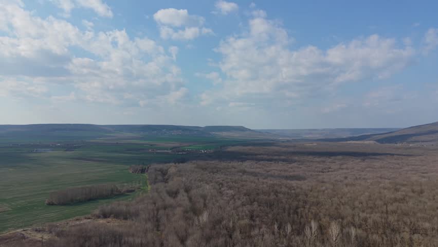 Scenic panorama of rural landscape with fields hills and blue sky with clouds