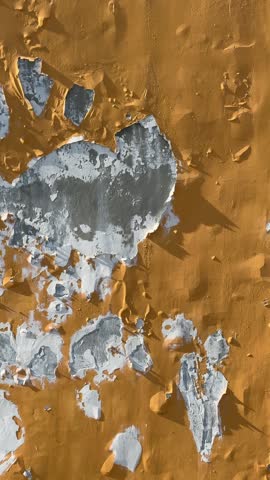 Close ground level shot focusing on cracked paint texture and worn exterior surfaces of residential housing.