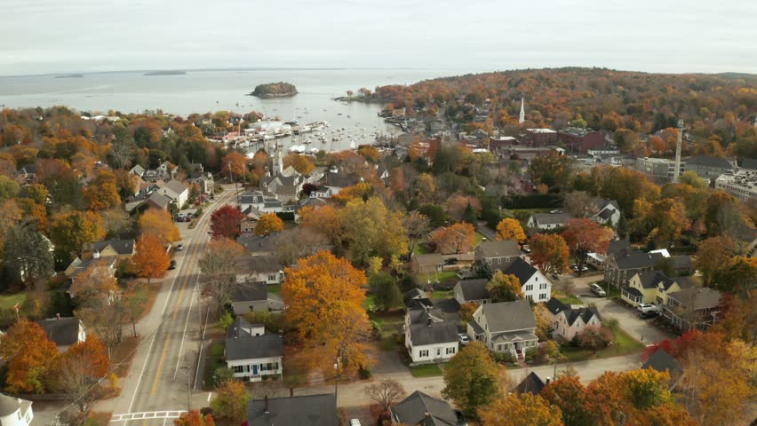 Aerial view of Camden Maine harbor during peak autumn foliage season with colorful trees and coastal scenery