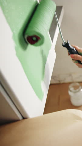 Painting, cupboard and hands with roller for home renovation, remodeling project and kitchen makeover. Color change, painter and person with equipment for diy house improvement, decoration or upgrade