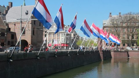 THE HAGUE, HOLLAND, MAY 5: Tram drives past large Dutch flags at the Dutch political center Binnenhof on May 5, 2013 in The Hague, Holland. The Hague is the residence of the Dutch parliament.