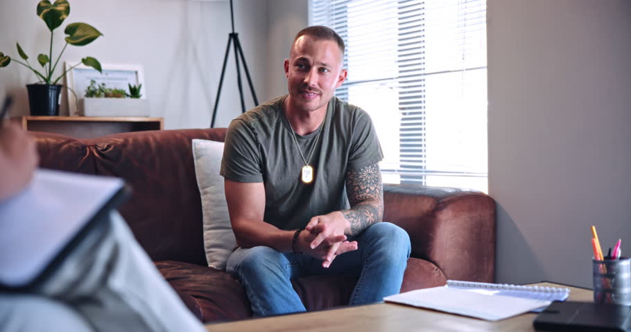 Counselling, talking and therapy with man on sofa for communication, healing or rehabilitation. Clipboard, notes and psychology with patient speaking to therapist in session for support or wellness