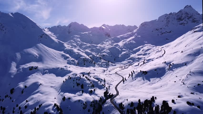 Experience the breathtaking winter majesty of the Austrian Alps from an entirely new perspective. This cinematic drone collection takes you on a high-altitude journey across some of the most iconic alpine regions in Austria: the vast slopes of Saalbach Hinterglemm, the dramatic glacier landscapes of the Kaunertal, the sun-drenched plateaus of Serfaus-Fiss-Ladis, and the stunning mountain-meets-lake panorama of Zell am See.

Filmed under perfect conditions, these shots showcase the Alps at their most spectacular. Every frame has been captured with professional-grade stabilization to ensure buttery-smooth motion, from sweeping orbits around jagged limestone peaks to slow, meditative glides over pristine powder fields. To bring out the soul of the landscape, the footage has undergone a professional color grading process, enhancing the deep sapphire blues of the alpine sky, the brilliant whites of the fresh snow, and the warm, golden hues of the winter sun hitting the ridges.

Whether it is the rhythmic patterns of freshly groomed corduroy on the world-class ski runs of Serfaus-Fiss-Ladis, the epic scale of the Kaunertal glacier roads, or the peaceful stillness of a frozen Lake Zell, this footage captures the essence of a European winter wonderland. You will see traditional alpine chalets tucked into snowy valleys, modern cable cars ascending towards the clouds, and the infinite horizon of the Hohe Tauern and Northern Limestone Alps.

Designed for travel documentaries, high-end commercial projects, or atmospheric relaxation films, this footage provides a majestic bird