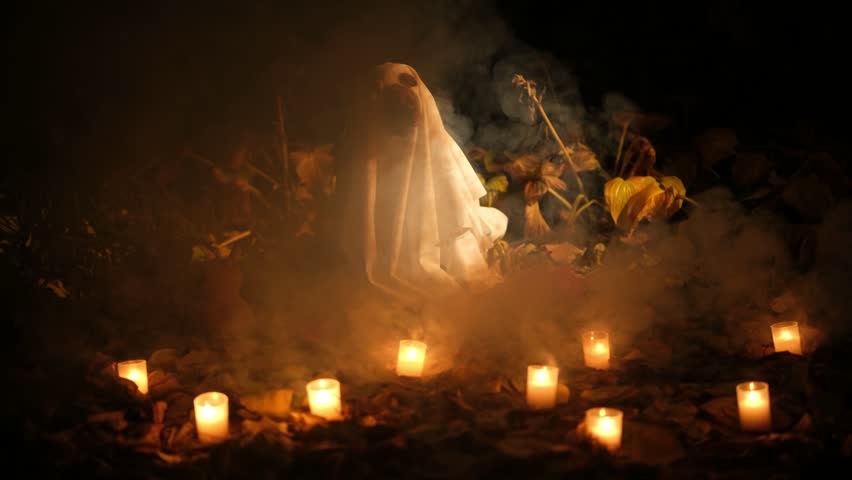 Funny english cocker spaniel wearing a ghost costume for halloween, sitting among glowing candles and autumn leaves in a dark, spooky, and foggy forest at night, celebrating the holiday