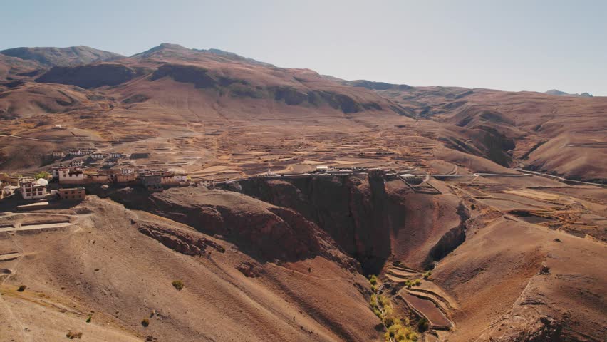 4K Aerial shot of Kibber village in Spiti Valley, Himachal Pradesh, India. Beautiful landscape of dry mountains and farm near Himalayan village during summer season. Travel and holidays background.
