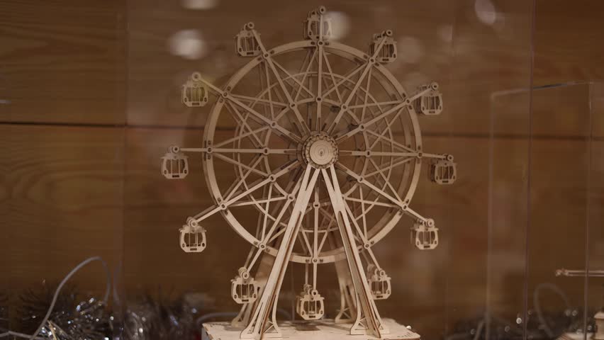 Close up of wooden kinetic ferris wheel model rotating mechanical construction moving gears craftsmanship engineering concept slow motion detail