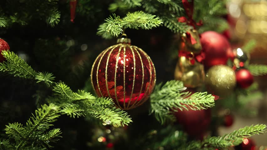 Cinematic close up of christmas tree ornaments with soft bokeh lights creating dreamy festive mood and elegant holiday atmosphere