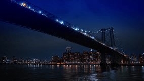 Williamsburg Bridge suspension structure over East River at night. Perspective view of the Williamsburg Bridge at night with New York City skyline in the background. - Powered by Shutterstock - Get 15% off with code: PIKWIZARD15