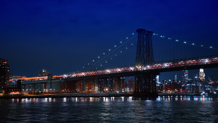 Steel structure of Williamsburg Bridge at night in NYC. Close up of the illuminated steel suspension towers and cables of the Williamsburg Bridge at night.