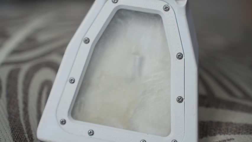 Extractor Filter Closeup Showing Foam Residue And Soapy Buildup, White Plastic Chamber Framed By Visible Screws, Transparent Panel Reveals Dirty Water Inside, Maintenance Technician Vibe, Industrial