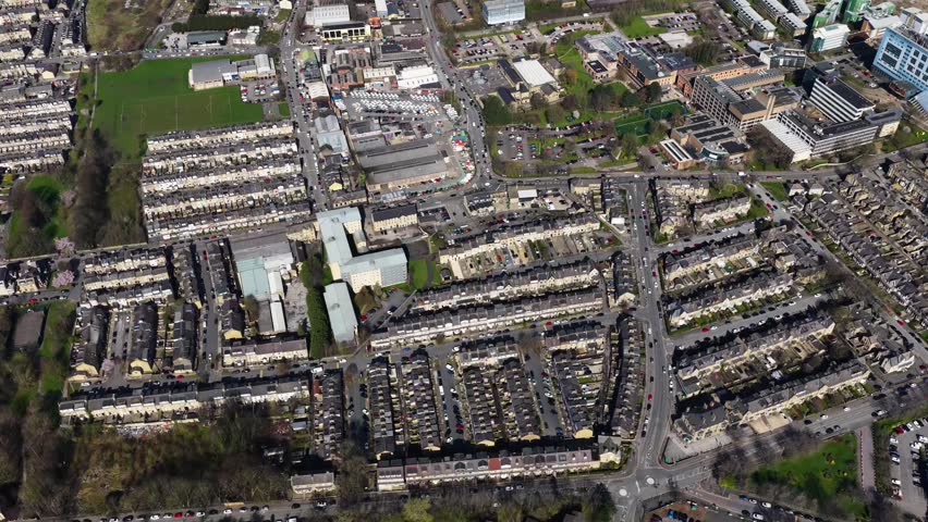 Aerial drone footage of the City of Bradford in Yorkshire in the UK showing the urban skyline historic architecture busy roads commercial districts residential areas and the wider Yorkshire landscape