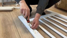 Process of assembling a baby cot. Soft focus. Man screws the side part with a screwdriver. Self-assembly of furniture at home - Powered by Shutterstock - Get 15% off with code: PIKWIZARD15