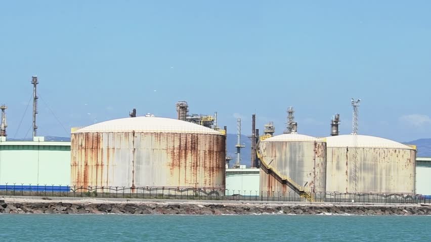 View from a ship of a group of storage tanks accumulating strategic oil reserves at a European oil depot on the Mediterranean coast. Inflation, rising fuel prices. Global market shortage. Iran war.