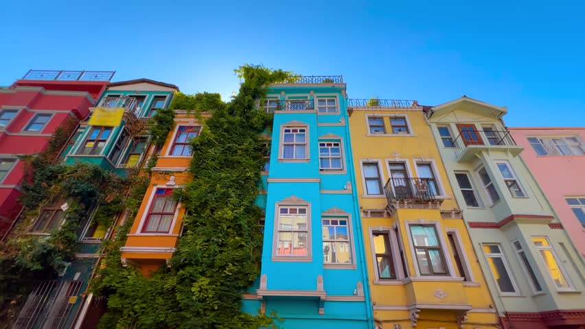 Wide angle front view of colorful house facades in Balat, Istanbul on a sunny day. Vibrant historic neighborhood and popular tourist attraction with bright urban architecture under blue sky