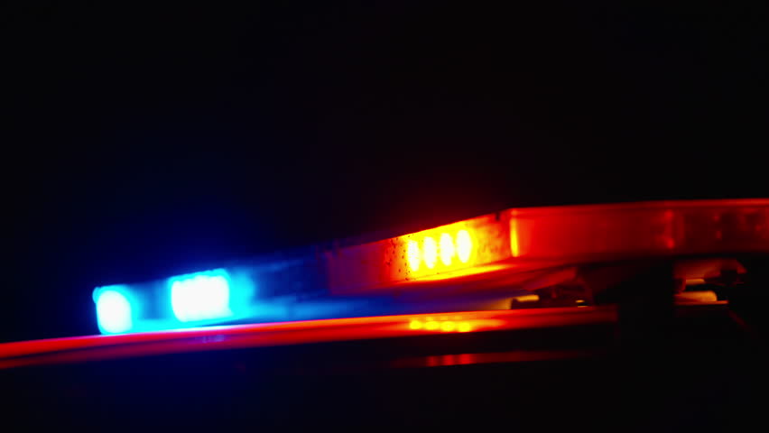 Close up of police lights flashing red and blue at night with strong blur and glow creating intense cinematic emergency scene and urban tension