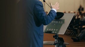 Close up of business speaker presenting at conference podium with microphone addressing audience representing public speaking leadership and corporate presentation. - Powered by Shutterstock - Get 15% off with code: PIKWIZARD15