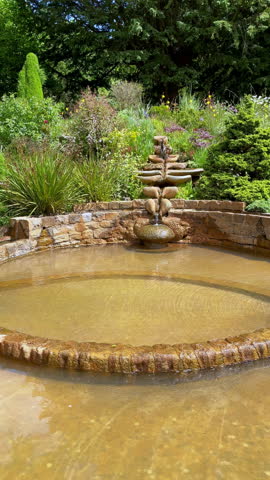 Meditative copper tiered fountain in a peaceful spiritual garden, UK