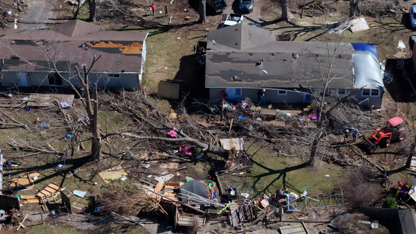 Aerial Drone shoot of residential neighborhood destruction after a tornado with damaged houses and scattered debris.