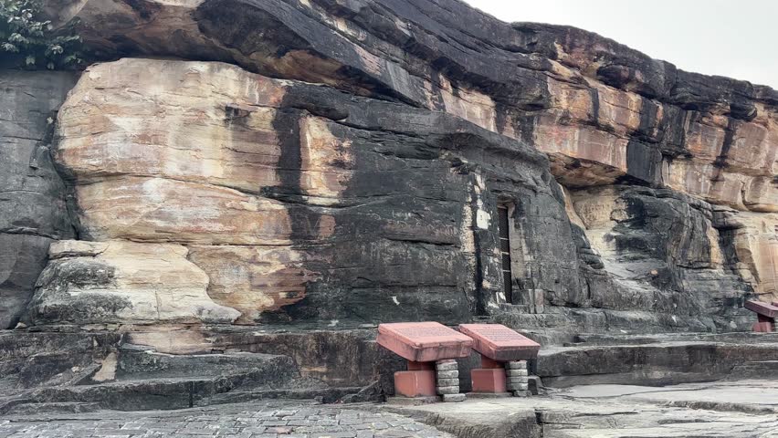 Pan left shot of rock wall at Udayagiri Caves, India