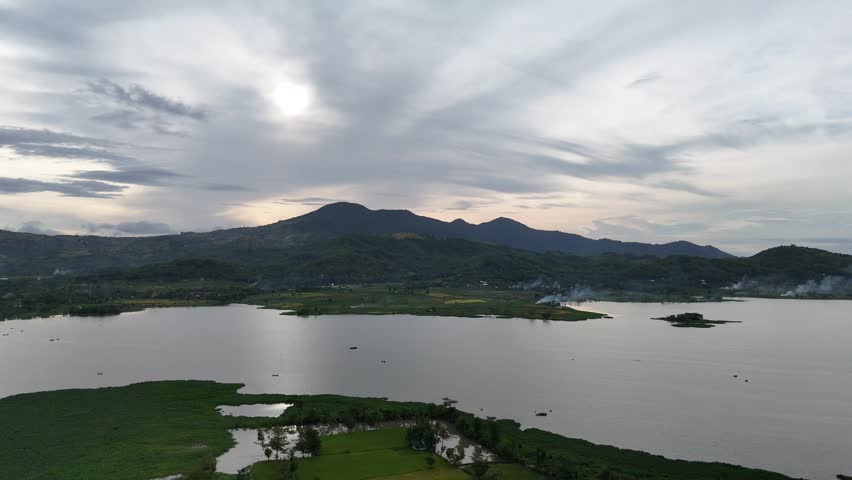 Aerial View of Serene Lake and Lush Mountains Under an Overcast Sky